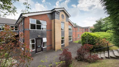 Exterior view of Wellington Lodge building with landscaping