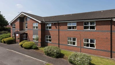 Exterior view of Wellington Lodge with landscaping