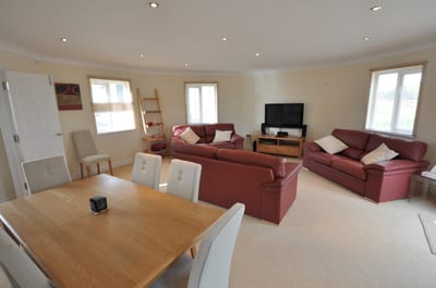 Bright common area with comfortable seating and a TV