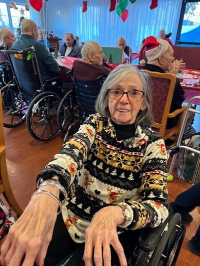 Resident smiling in festive attire during a holiday gathering