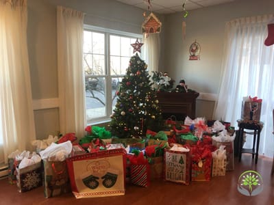 Festively decorated common area with Christmas tree and gifts