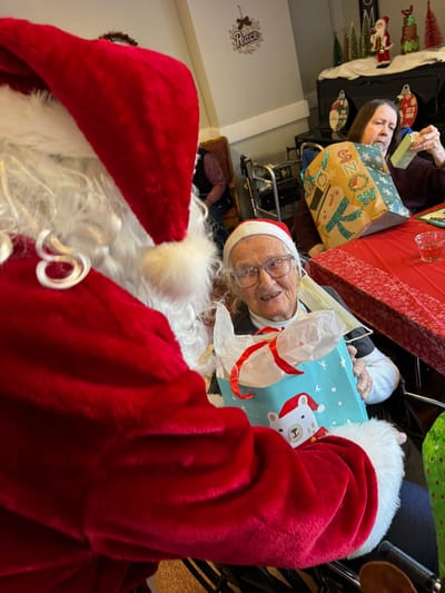 Resident with Santa at a Christmas celebration