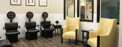 Hair salon area with styling chairs and mirrors