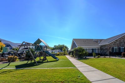 Play area with a slide and grassy lawn