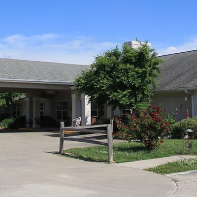 Exterior view of the facility with garden and driveway.