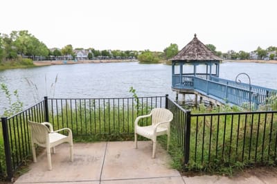 Outdoor seating by a serene lake and gazebo
