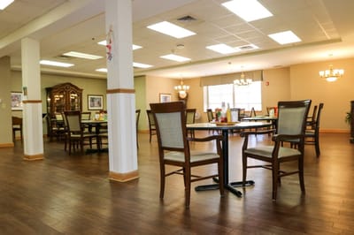Dining area with tables and chairs, ready for residents.