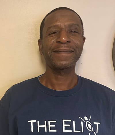 Resident wearing a facility t-shirt, smiling.