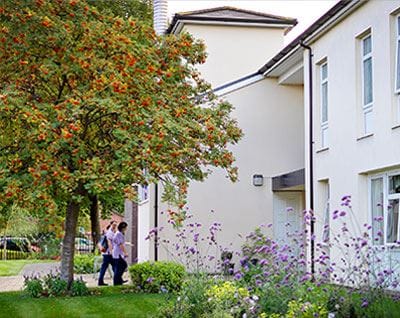 Residents walk near the facility's landscaped gardens.