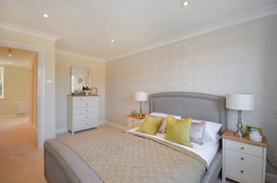 A well-decorated bedroom with a bed and dresser.