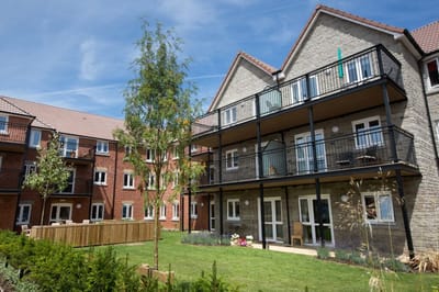 Exterior view of residential buildings with green space.
