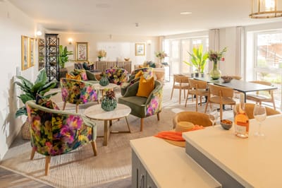 Bright common area with colorful seating and plants.