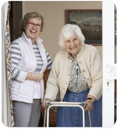 Caregiver and resident smiling at the door