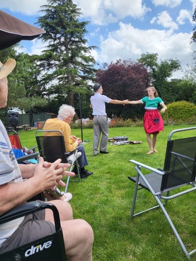Residents enjoying a dance performance outdoors