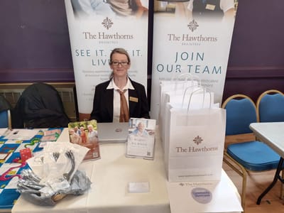 Staff member at a promotional table with brochures.