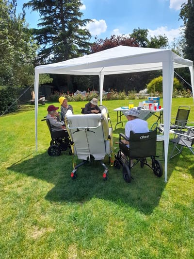 Residents enjoying outdoor activity under a tent.