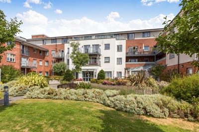 Exterior view of a retirement living facility with garden.