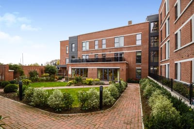 Brick building with garden and patio area