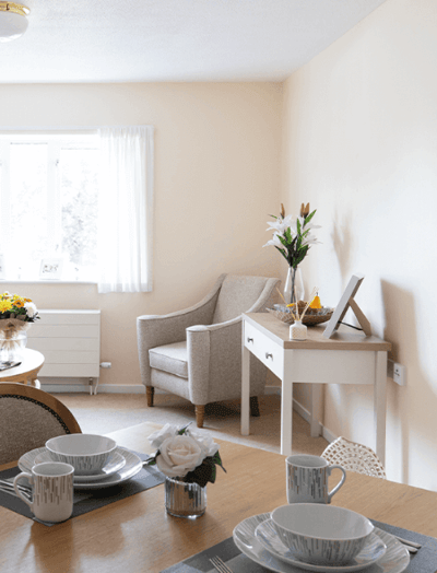 Cozy living area with light decor and floral accents.