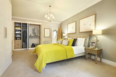 Stylish bedroom with a yellow quilt and artwork.
