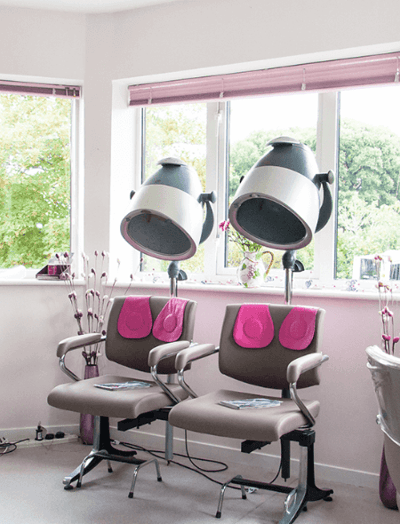 Hair salon chairs with dryers in a bright room