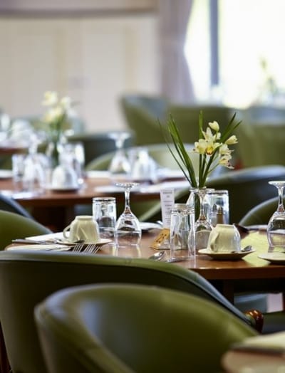 Elegant dining room setup with tables and flowers.