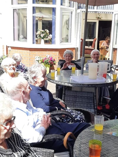 Residents enjoying a sunny day outdoors at the facility