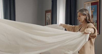 Staff member arranging bedding in a room