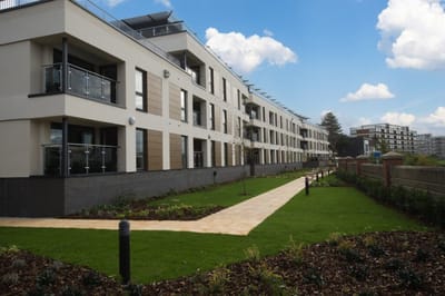 Modern assisted living facility exterior with landscaped path