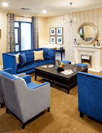 A cozy common area with blue sofas and decor.