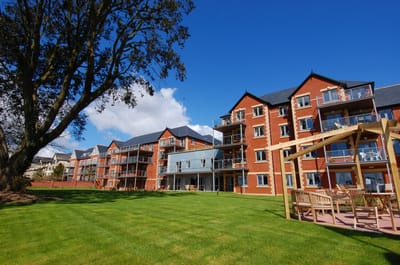 Exterior view of a retirement living facility with outdoor seating.