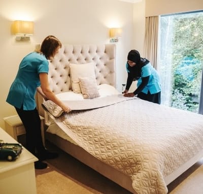Staff making a bed in a resident room