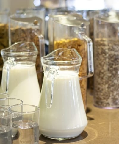 Pouring milk into glasses at a dining area