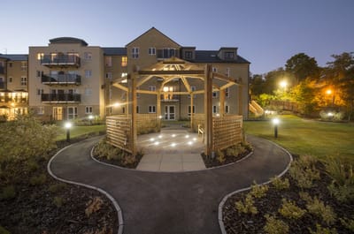 Outdoor gazebo with landscaped garden at dusk.