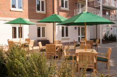 Outdoor seating area with green umbrellas and wooden tables