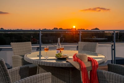 Outdoor dining setup with sunset view.