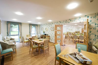 Bright common area with dining tables and comfortable seating.