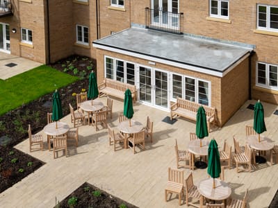 Outdoor seating area with green umbrellas and benches