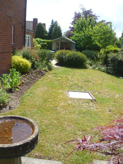 Well-maintained garden area with shrubs and a gazebo.