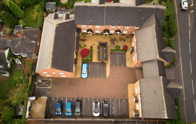 Aerial view of Pilgrim Gardens' exterior and parking area.