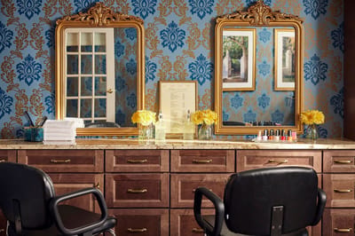Interior view of a salon area with mirrors and flowers