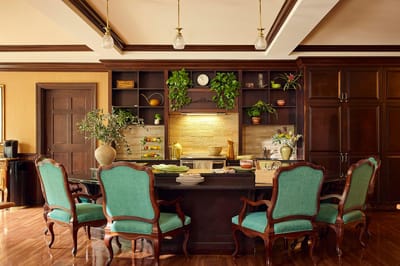 Interior dining area with green chairs and kitchen.
