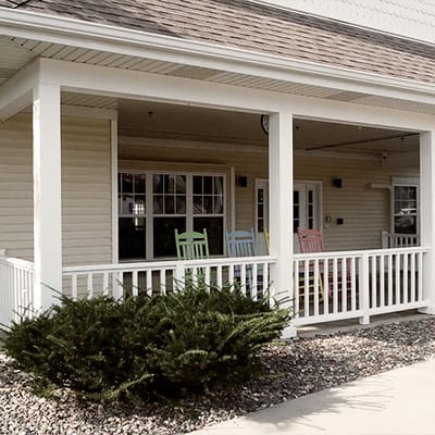 Porch with colorful rocking chairs and greenery