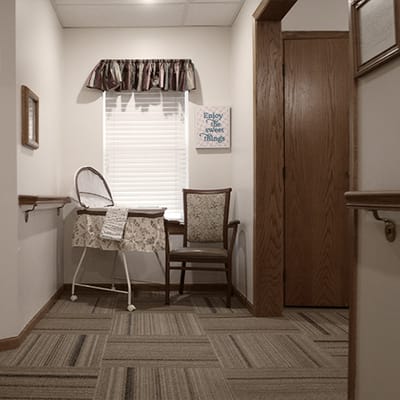A cozy corner in a senior living facility with a chair and decor