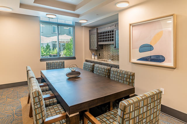 Bright common area with a large table and patterned chairs