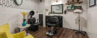 Hair salon area with chairs and decorative wall