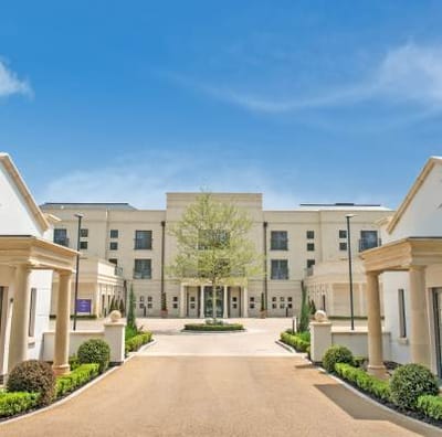 Building exterior of a senior living facility with landscaped entrance