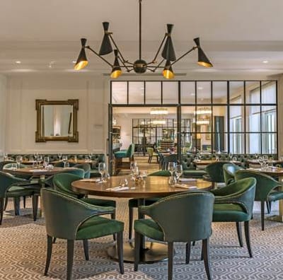 Elegant dining room with green chairs and decorative lighting