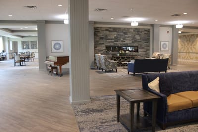 Bright common area with seating and a piano