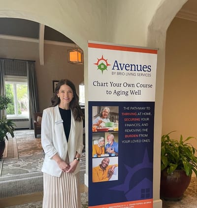 Staff member next to a facility banner promoting services